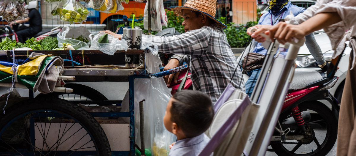 Un vendedor ambulante de comida espera clientes en su carrito en Bangkok
