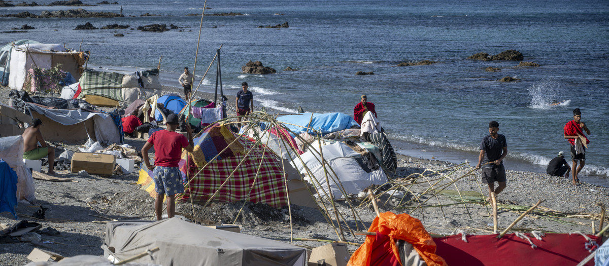 Migrantes en campamentos improvisados en la playa, a 27 de agosto de 2026, en Ceuta (España). Los manifestantes han tratado de impedir el acceso de los voluntarios de Cruz Roja que reparten bolsas de comida a los migrantes en la playa del Trampolín y han provocado disturbios en la playa de Benítez de Cueta, que se han saldado con cargas policiales, tras introducirse en los asentamientos de migrantes que pernoctan en la zona y causar destrozos, incluido la quema de enseres.

Marcos Moreno / Europa Press
27 AGOSTO 2026 CRISIS MIGRATORIA;PIXELADA
27/8/2026