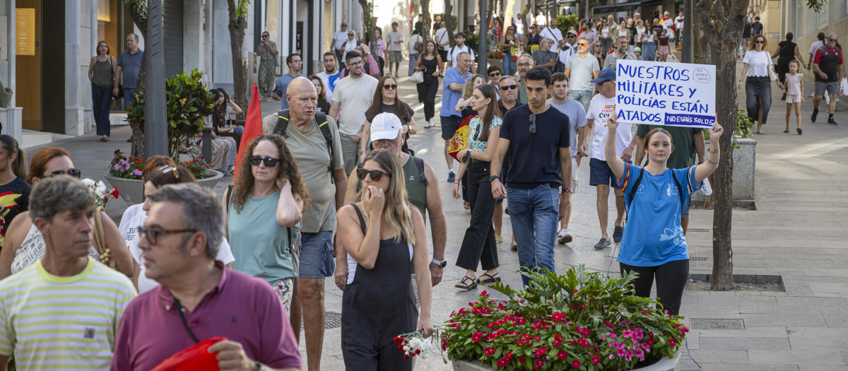 Numerosas personas portan claveles y banderas de España durante una manifestación ante la Delegación del Gobierno, a 28 de agosto de 2026, en Ceuta (España)