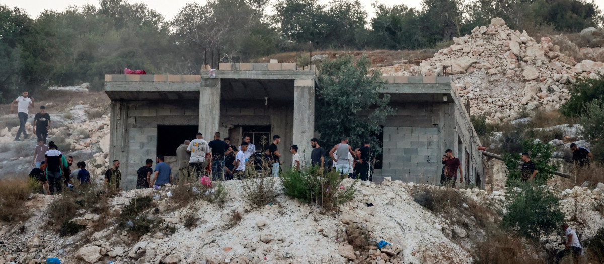 Ciudadanos palestinos inspeccionan una casa después de que el ejército israelí se retirara, sacando los cuerpos de tres palestinos muertos que, según el ejército, eran militantes, en las afueras occidentales de la ciudad norteña de Jenin