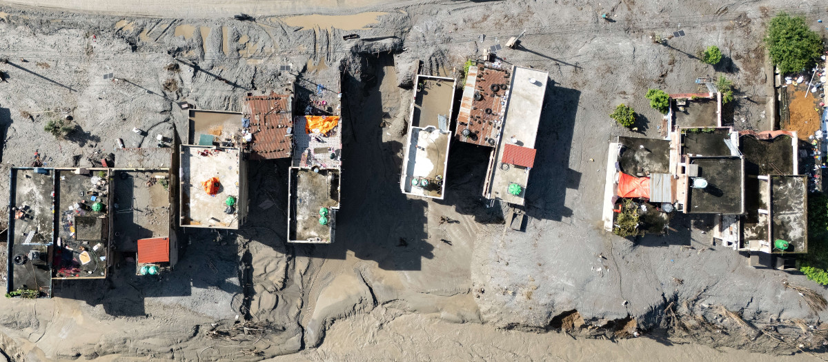 Una vista aérea muestra un vehículo circulando junto a casas cubiertas de barro tras unas inundaciones repentinas en Baireni, en el distrito nepalí de Dhading