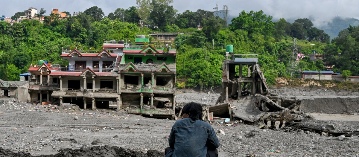 Un hombre observa casas dañadas tras unas inundaciones repentinas en el centro de Trishuli, en el distrito nepalí de Nuwako