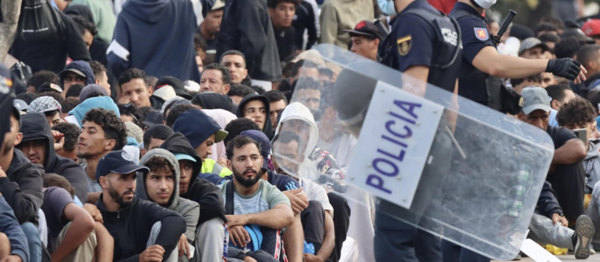 Inmigrantes frente a la explanada de embotellamiento de Loma Colmenar