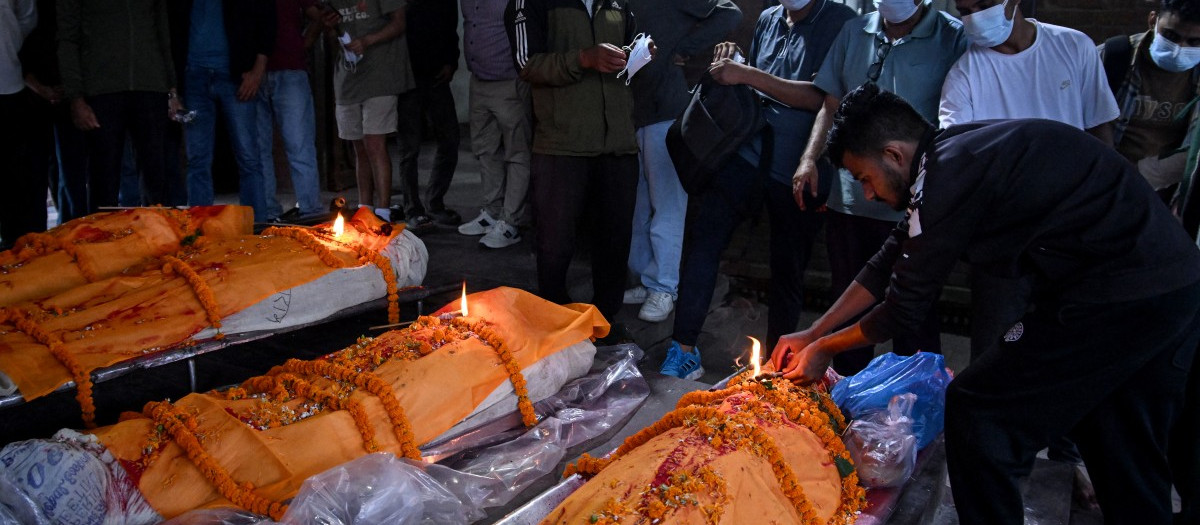 El hijo de Ram Chandra Khanal (en primer plano, a la derecha) participa en los ritos funerarios de su padre —víctima de una crecida repentina— antes de su cremación en el templo de Pashupatinath, en Katmandú