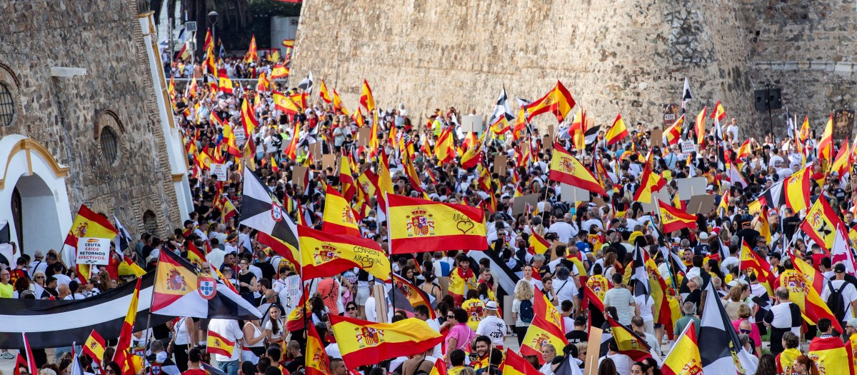 Manifestantes portan banderas de España durante una protesta para exigir la vuelta a la normalidad, un mes después de la llegada masiva de migrantes a Ceuta