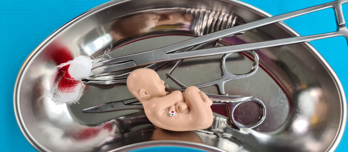 Concepto de aborto con feto bebé y herramienta médica