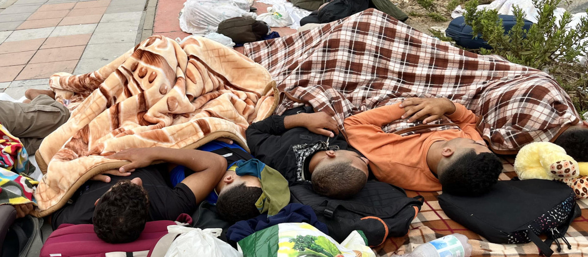 Varios inmigrantes duermen en las inmediaciones de la explanada de embolsamiento de Loma Colmenar