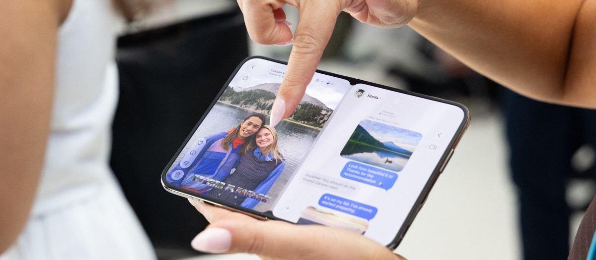 Un asistente manipula el iPhone Duo de Apple, el primer teléfono inteligente plegable de la compañía