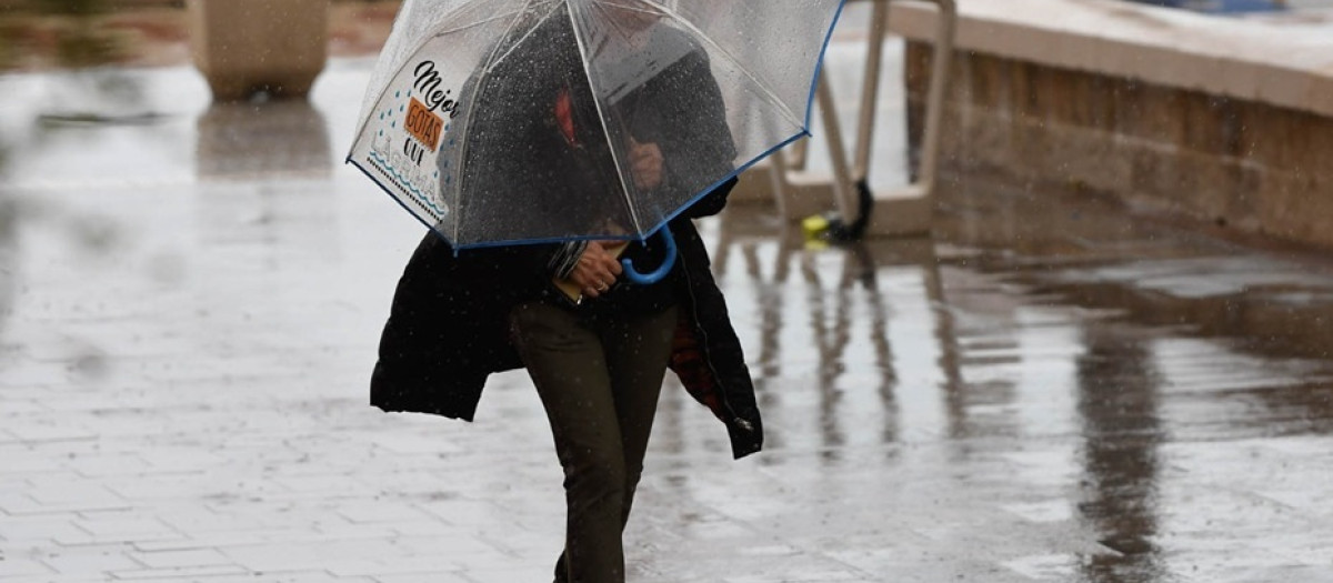 Imagen de una mujer protegiéndose de las lluvias