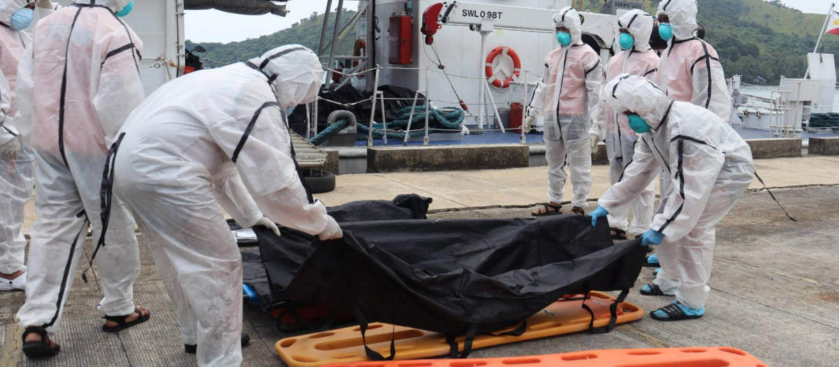 Efectivos de los guardacostas filipinos trasladan los restos mortales de las personas fallecidas en un incendio de un barco de pasajeros