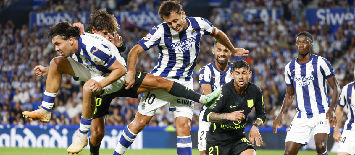 Los jugadores de la Real Sociedad y del Atlético de Madrid luchan por un balón