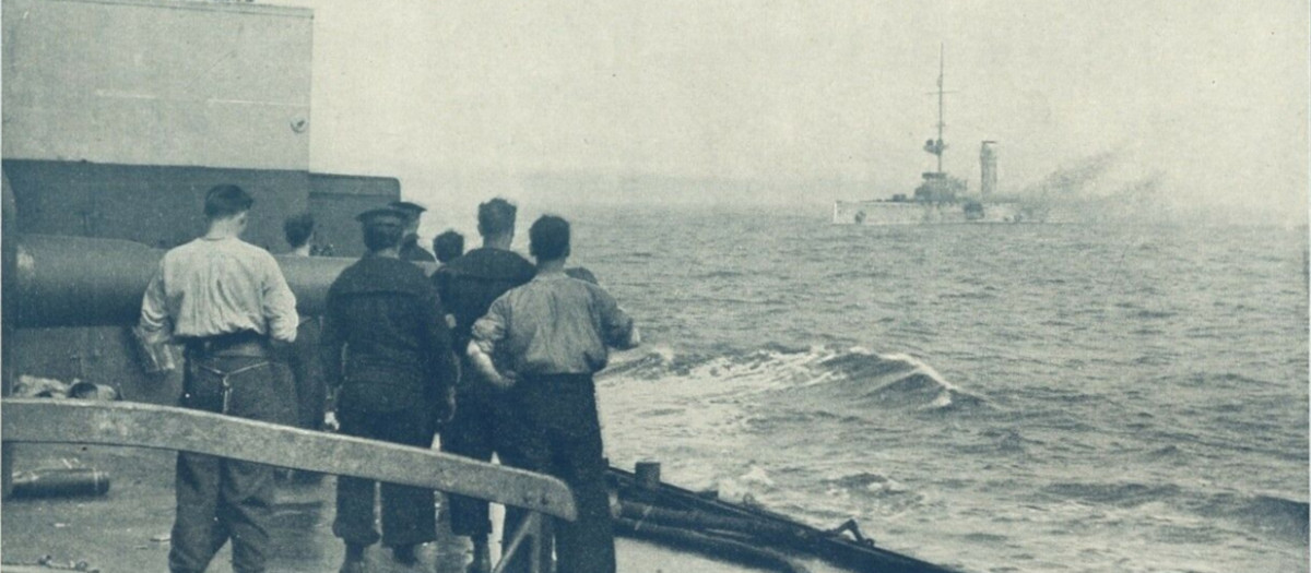 Los marineros británicos observan el gravemente dañado Mainz en llamas, momentos antes de hundirse