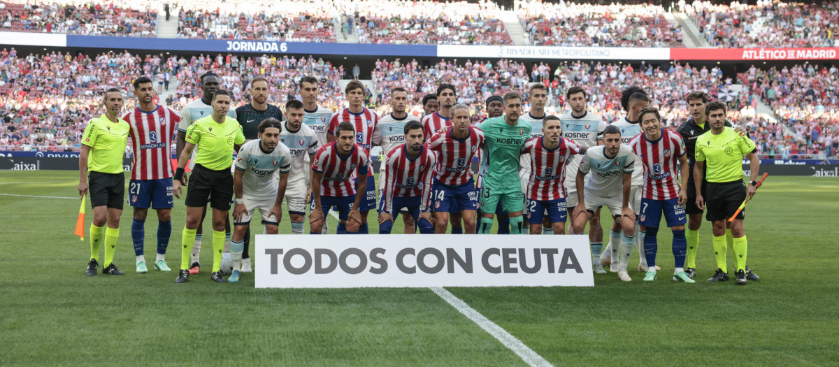 Los jugadores de Atlético de Madrid y Osasuna posan delante de un cartel de 'Todos con Ceuta'