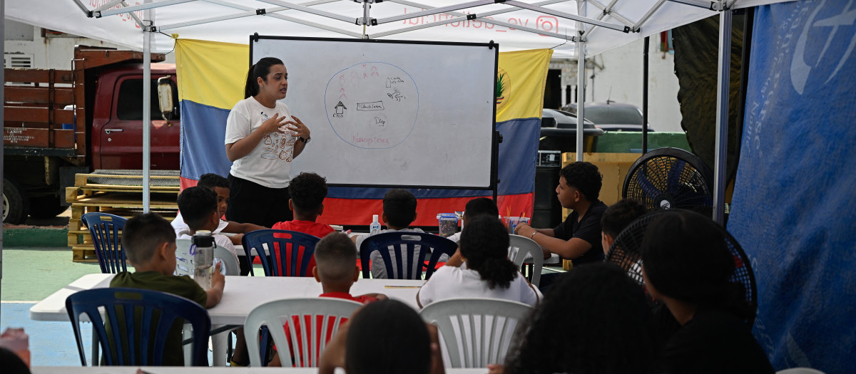 Los estudiantes asisten a clases dentro de un aula temporal instalada en una carpa el primer día del nuevo año escolar en La Guaira, Venezuela