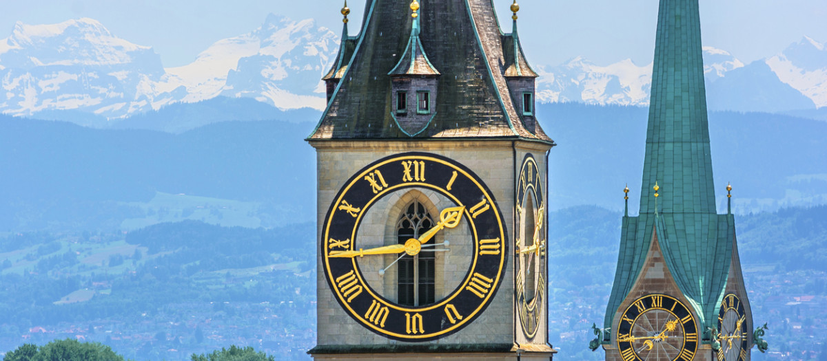Las torres de las iglesias de San Pedro y de Fraumünster, una imagen habitual de Zúrich (Suiza), frente al lago Zúrich y los Alpes al fondo