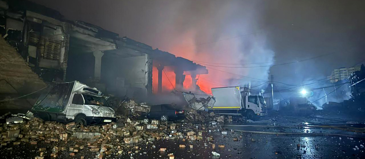 un edificio en llamas y vehículos dañados tras un ataque aéreo a una empresa agrícola en Stara Hnylytsia, región de Kharkiv,