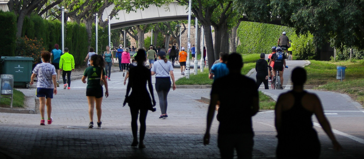 Personas caminan por el parque del Río Turia