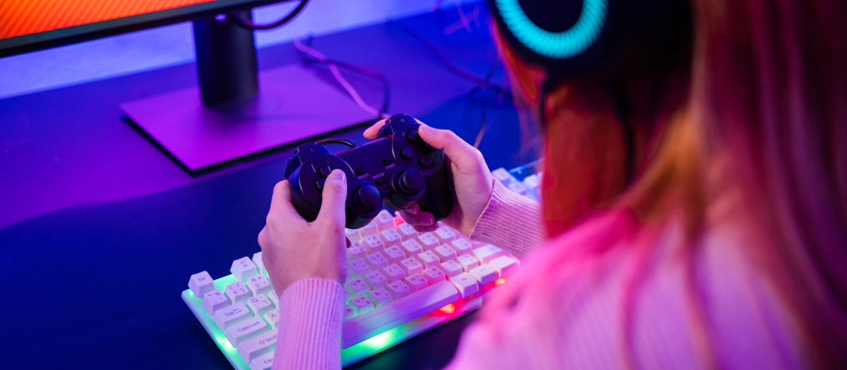 Una chica juega con un joystick a un videojuego