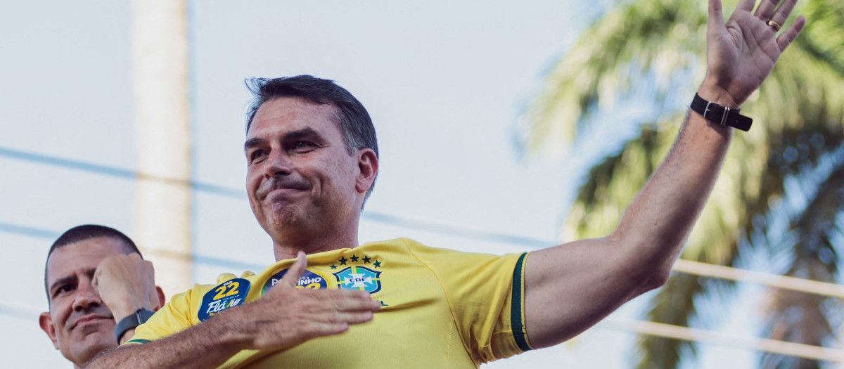 Brazilian right-wing presidential candidate Flavio Bolsonaro, of the Liberal Party (PL), gestures as he rides in a motorcade with supporters in the Jacarepagua neighborhood in Rio de Janeiro, Brazil, on September 26, 2026. Brazil will hold presidential election on October 4, 2026. (Photo by Douglas SHINEIDR / AFP)