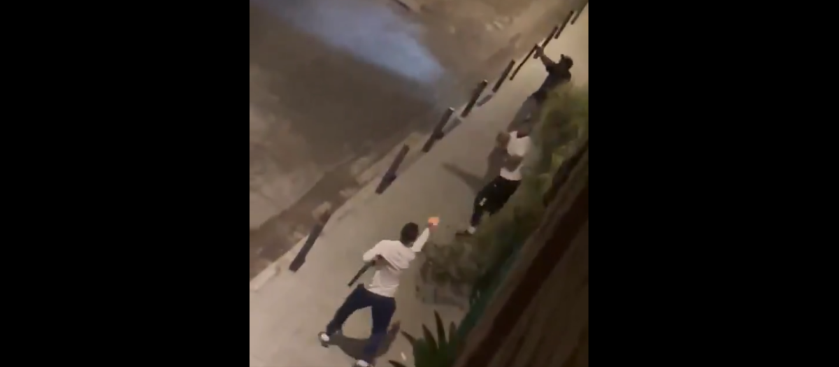Uno de los delincuentes, abajo, apunta a los dos agentes mientras porta una escopeta