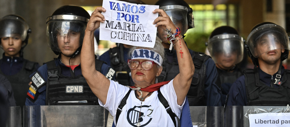 Un activista político, sostiene una pancarta con el lema "¡Vamos, María Corina!" durante una manifestación