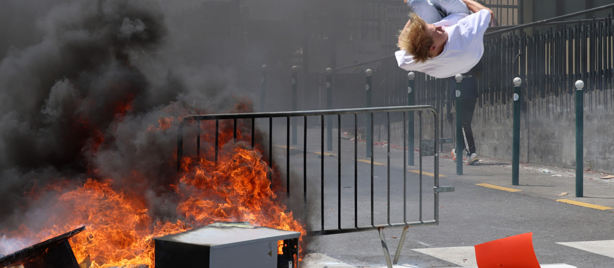 Un manifestante salta sobre una hoguera durante las protestas estudiantiles en Saint-Pierre, en la isla francesa de ultramar de La Reunión,