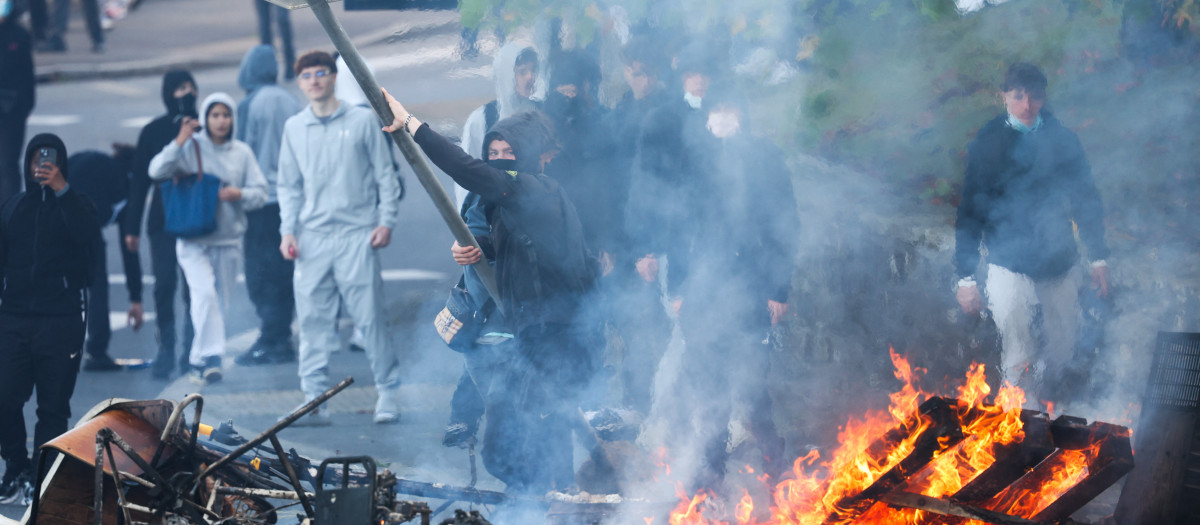Un manifestante arroja una señal de stop al fuego mientras estudiantes realizan un bloqueo cerca del instituto Kerichen en Brest, al oeste de Francia