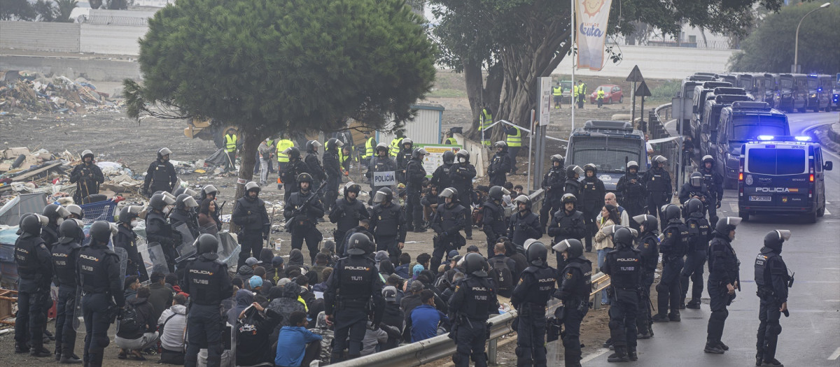Agentes de la Policía Nacional intervienen durante el proceso de desalojo del embolsamiento de migrantes en la playa de El Trampolín