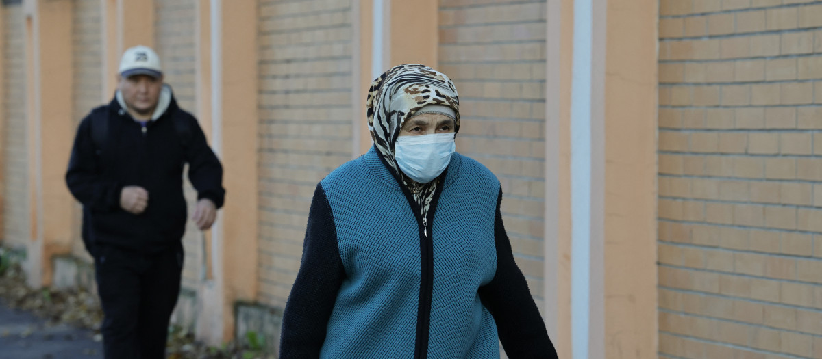 Una mujer con mascarilla pasa frente al instituto de lucha contra epidemias en la ciudad de Irkutsk