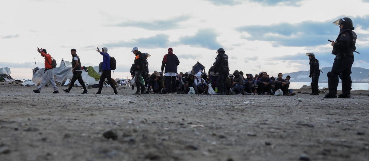 Un grupo de inmigrantes que ocupaban la explanada del Guano en Ceuta siendo desalojados por la Policía Nacional