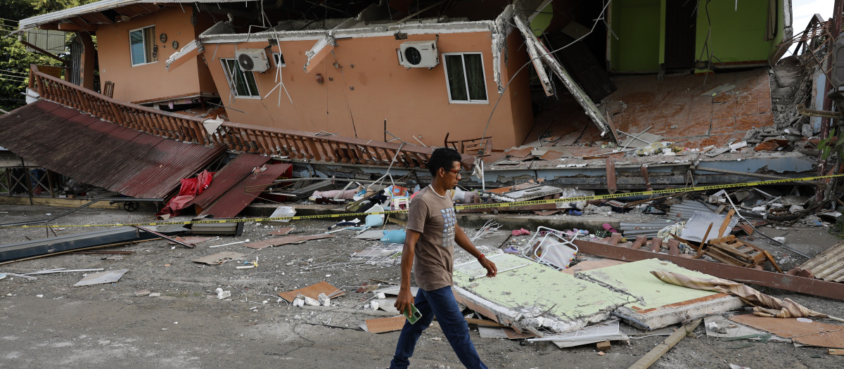 Un hombre camina cerca de una vivienda afectada el terremoto en Tonosí