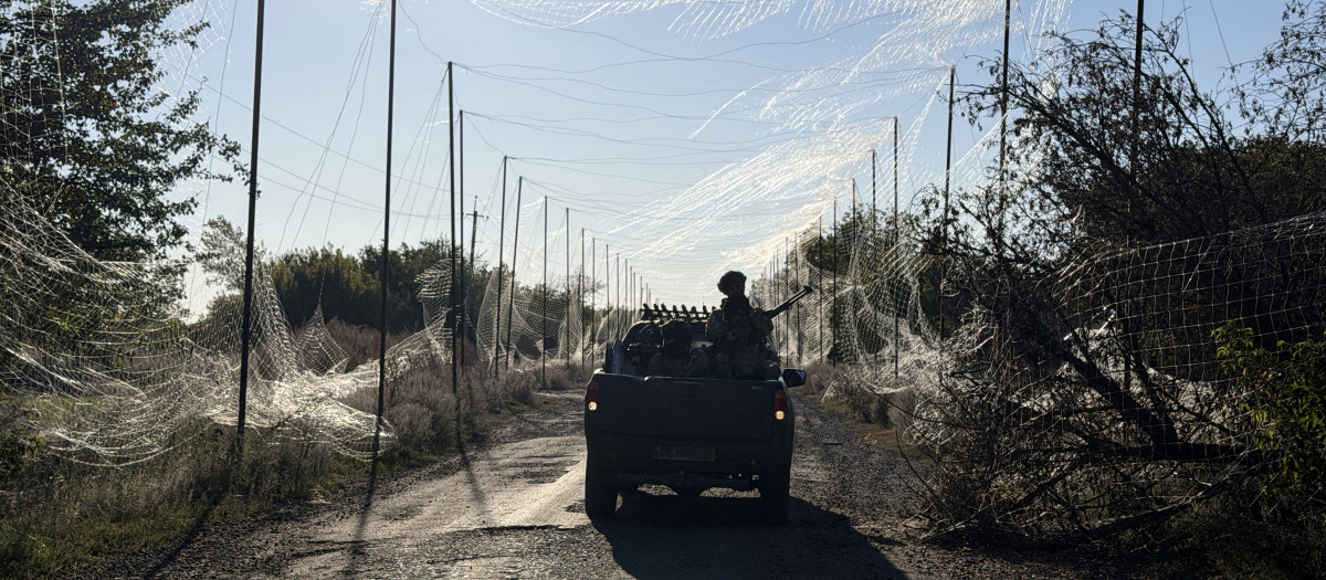 Un militar de la 141.ª Brigada Mecanizada Independiente de Ucrania viaja en una camioneta bajo la red antidrones en la aldea de Prosyana, en la región de Dnipropetrovsk