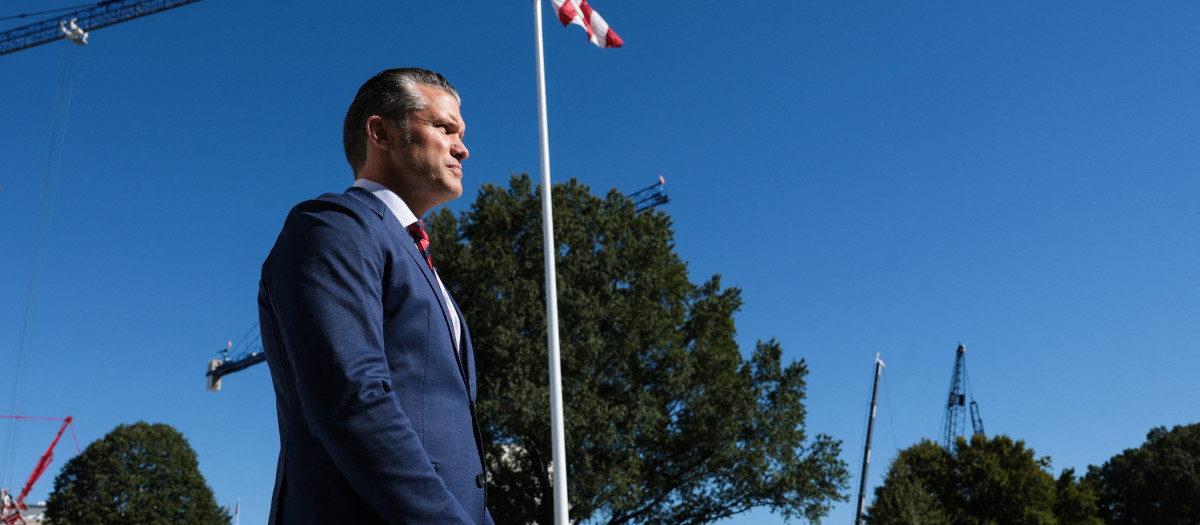 El secretario de Guerra de Estados Unidos, Pete Hegseth, observa mientras el presidente Donald Trump habla con los medios de comunicación al partir del jardín sur de la Casa Blanca en Washington, DC