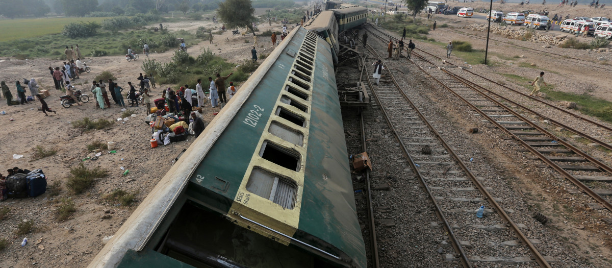 Pasajeros se congregan mientras las ambulancias hacen fila en el lugar del descarrilamiento del tren de pasajeros Rehman Baba Express