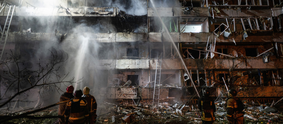 Bomberos ucranianos extinguen un incendio en el lugar donde un misil ruso atacó un edificio de apartamentos en Kiev
