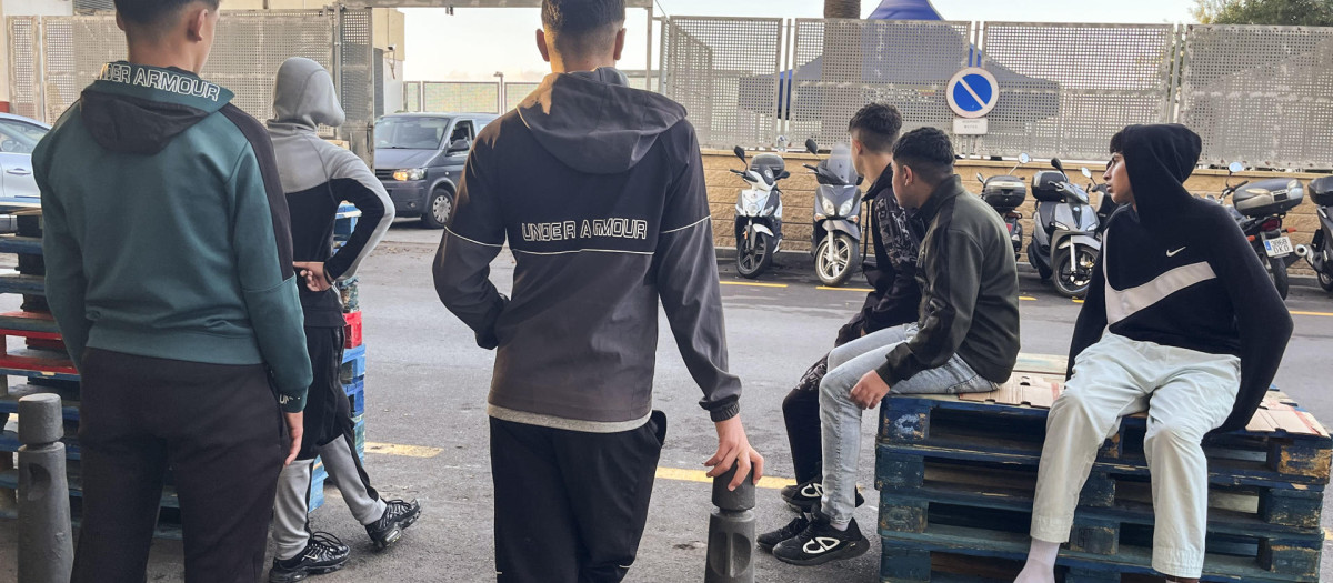 Menores inmigrantes esperan  frente a la Jefatura Superior de la Policía Nacional de Ceuta
