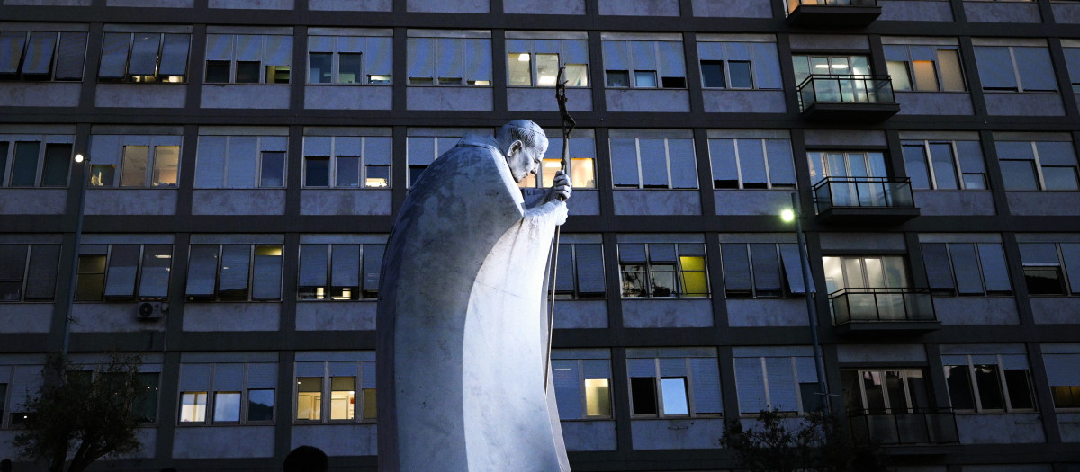 La gente reza ante la estatua de Juan Pablo II situada frente al Hospital Universitario Gemelli