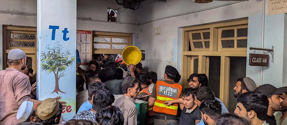 Rescatistas y residentes durante una operación de búsqueda tras el derrumbe del techo de una escuela en Peshawar.