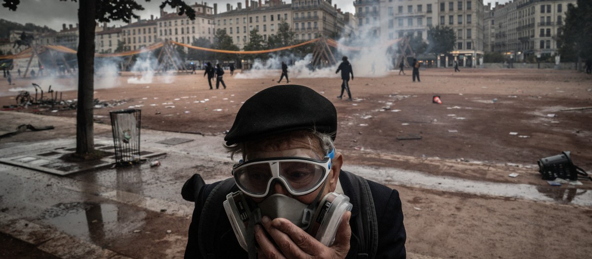 Un anciano utiliza una máscara antigás para protegerse del humo de los gases lacrimógenos