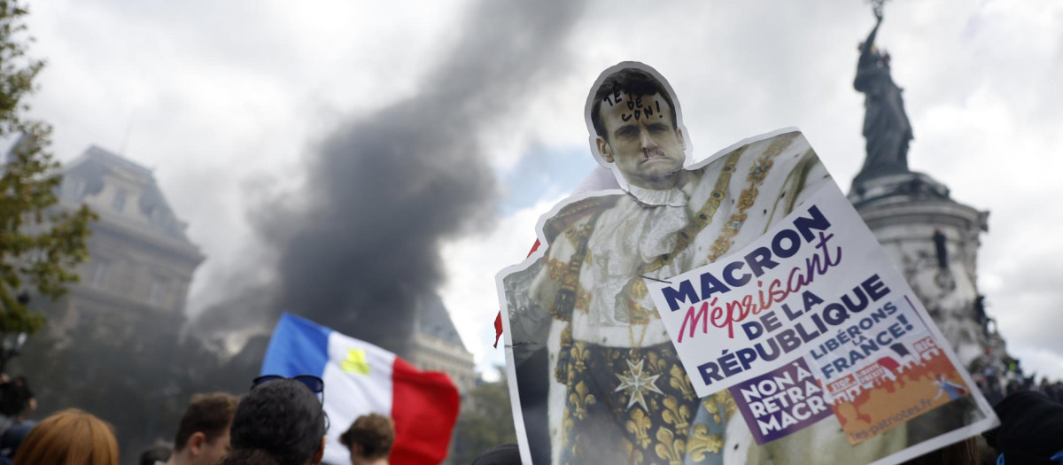 Un manifestante pide explicaciones al presidente de Francia, Emmanuel Macron