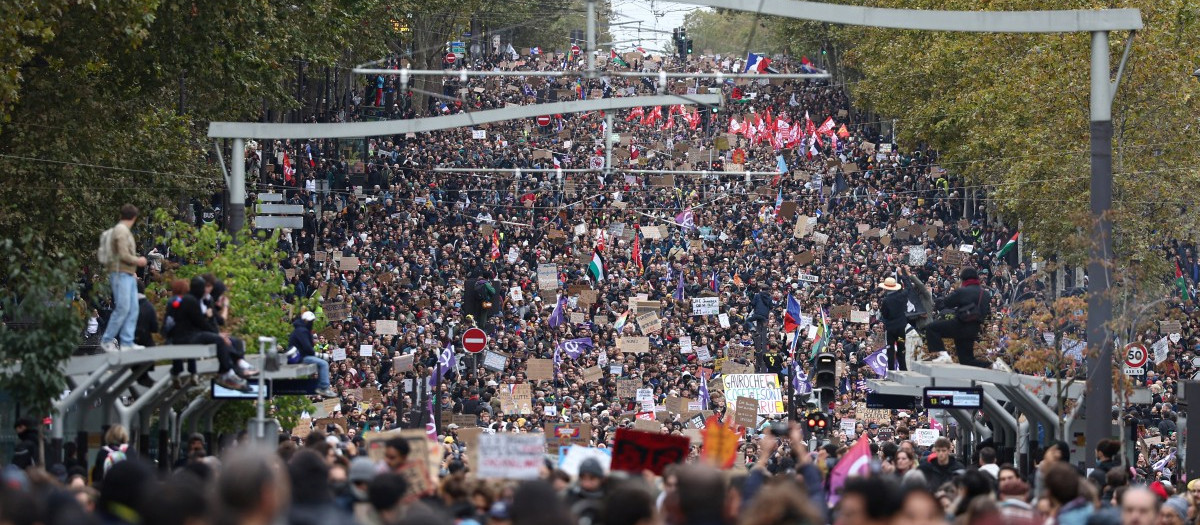 Protesters march during a demonstration in favor of purchasing power, the protection of public services, and fiscal and social justice, in Paris on October 24, 2026 as part of a nationwide call for mobilisation bringing together former members of the Yellow Vest movement, labor unions, high school and university students. Protests by high school students over learning conditions sparked a movement that has since spread nationwide, fuelled by broader anger over the rising cost of living. About 70,000 security personnel will be deployed on October 24, 2026, Interior Minister said at a news conference, warning that calls for violence and looting were circulating on social media. (Photo by Sameer AL-DOUMY / AFP)
