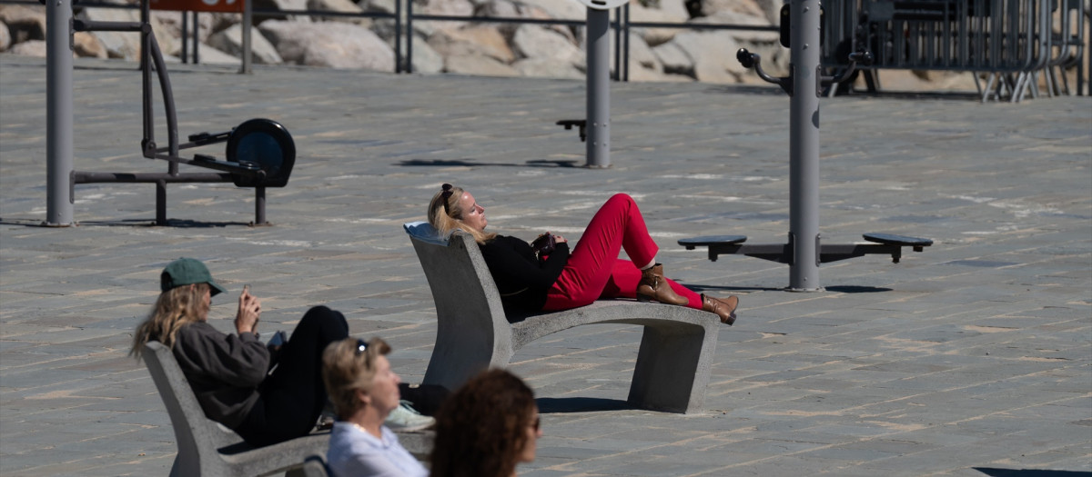 (Foto de ARCHIVO)
Varias personas toman el sol en el paseo marítimo de la playa del Bogatell