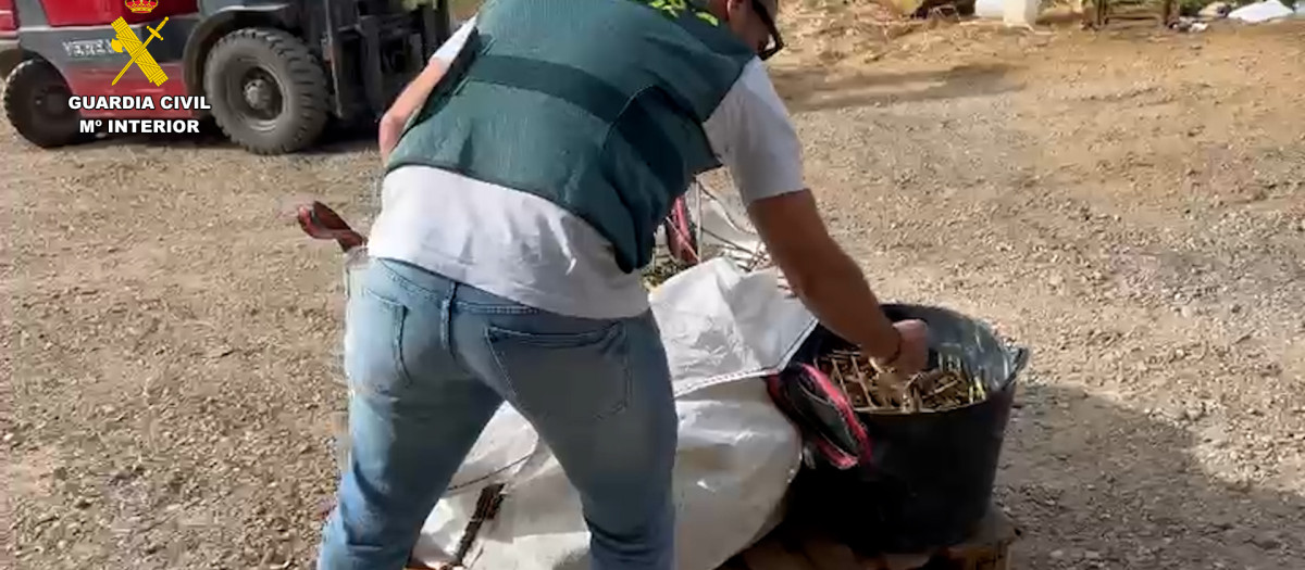 Un agente de la Guardia Civil junto a algunos objetos recuperados