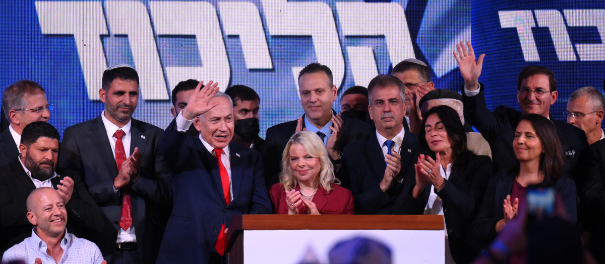 El primer ministro israelí, Benjamin Netanyahu (centro izquierda), saluda a sus seguidores junto a su esposa Sara en el mitin de la noche electoral tras el anuncio de los primeros sondeos a pie de urna, en Jerusalén