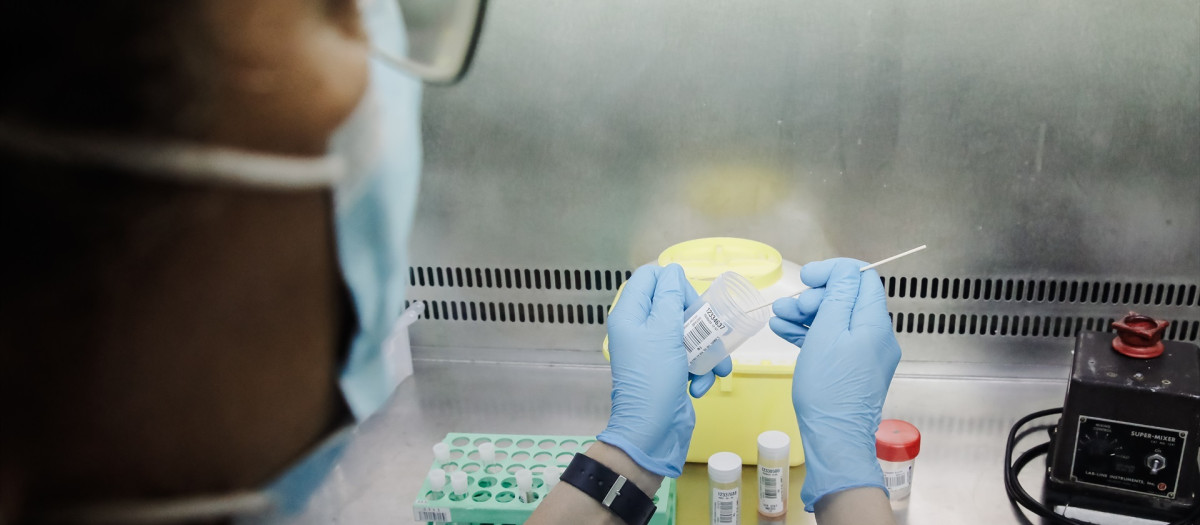 Una técnico de laboratorio sostiene pruebas de análisis