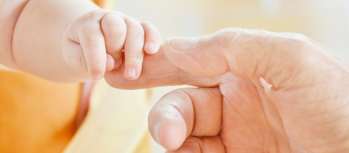 Imagen de archivo de la mano de un bebé y la de su madre