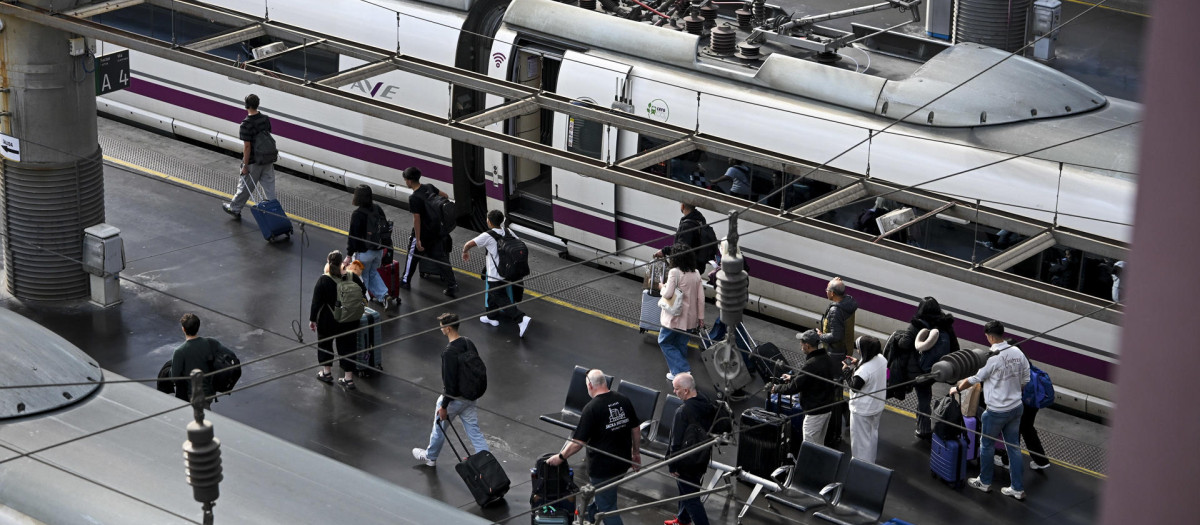 Varios pasajeros pasan ante un AVE en la Estación de Atocha, de donde partió el tren accidentado en Urda (Toledo)
