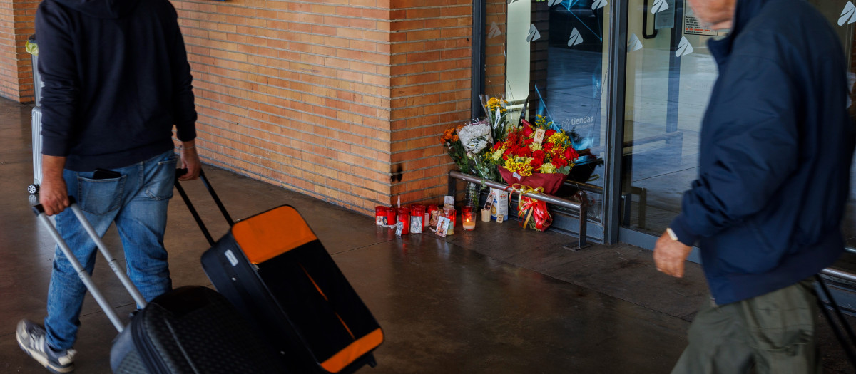 Viajeros pasan ante el altar improvisado en la estación de Santa Justa en Sevilla, donde más de 200 personas han guardado cinco minutos de silencio en recuerdo de las víctimas del accidente ferroviario de Urda (Toledo)