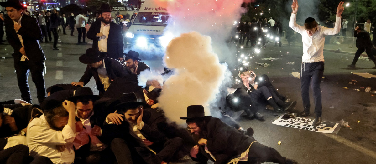 Judíos ultraortodoxos, en su mayoría exentos del servicio militar, reaccionan mientras la policía dispara granadas aturdidoras para dispersarlos durante una protesta contra su reclutamiento para el servicio militar obligatorio cerca del centro de la ciudad israelí de Bnei Brak el 29 de octubre de 2026.