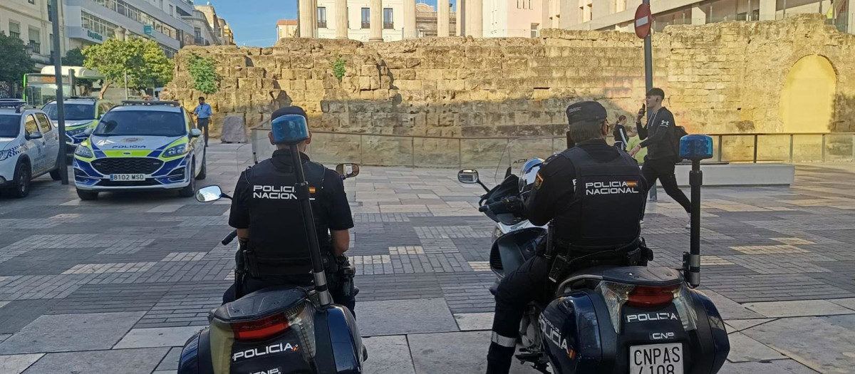 Dos agentes de la Policía Nacional, en un dispositivo preventivo en la calle Capitulares, ante el Templo Romano y el  Ayuntamiento de Córdoba